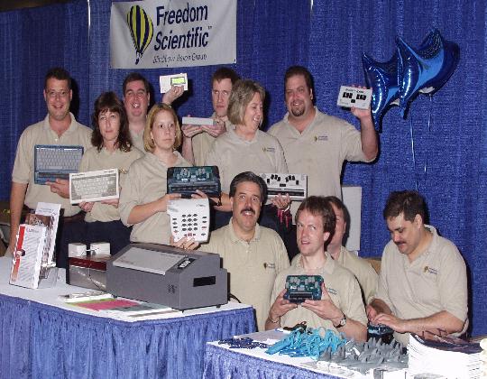 Is it safe to get in the water?: The staff of the Freedom Scientific booth
holds up a variety of products, including a Braille 'n Speak and a Type 'n
Speak, while several mylar Jaws balloons swim around in the air.