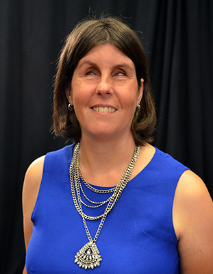 Katie Frederick in a royal blue dress with pendant necklace