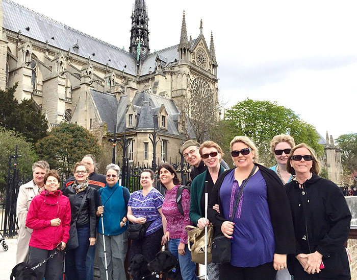 The travel group in front of the Notre Dame Cathedral. Vicky Prahin and Katie Frederick stand side by side in the center of the group.